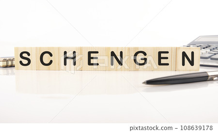 Schengen word assembled from wooden cubes next to a calculator, pen and notepad Schengen word assembled from wooden cubes next to a calculator, pen and notepad 108639178