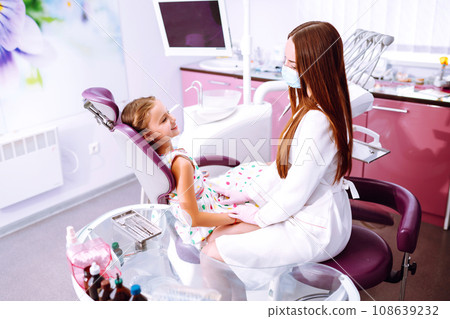 Lovely little girl smiling after doing examination in a pediatric stomatology. Milk teeth care. 108639232