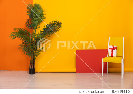 Vintage chair with gift in interior on yellow background Vintage chair with gift in interior on yellow background 108639410