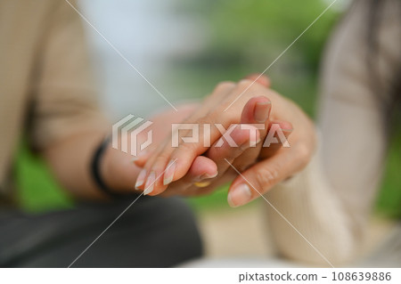 Caring young adult daughter holding hand of mature father showing love and support 108639886