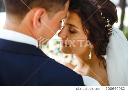 The bride and groom walk together in the park. Pretty bride and stylish groom. Wedding day. Marriage. 108640082