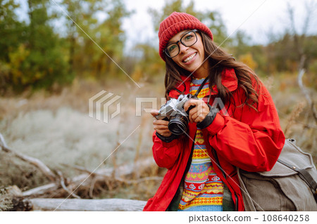 Smiling woman enjoying autumn weather. Rest, relaxation, lifestyle concept. Smiling woman enjoying autumn weather. Rest, relaxation, lifestyle concept. 108640258