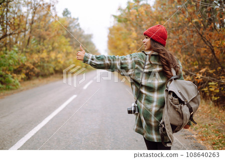 Travel woman hitchhiking. Rest, relaxation, travel, lifestyle concept. Travel woman hitchhiking. Rest, relaxation, travel, lifestyle concept. 108640263
