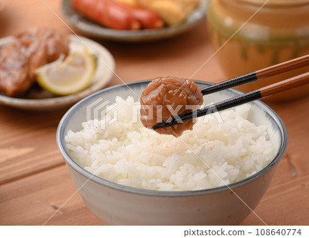 Pick up the pickled plums on rice with chopsticks Pick up the pickled plums on rice with chopsticks 108640774