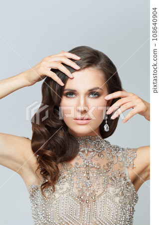 Stylish brunette woman with makeup, healthy hair and luxurious jewelry earring Stylish brunette woman with makeup, healthy hair and luxurious jewelry earring 108640904