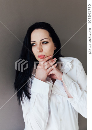 Portrait of a beautiful brunette woman in a white business suit Portrait of a beautiful brunette woman in a white business suit 108641780
