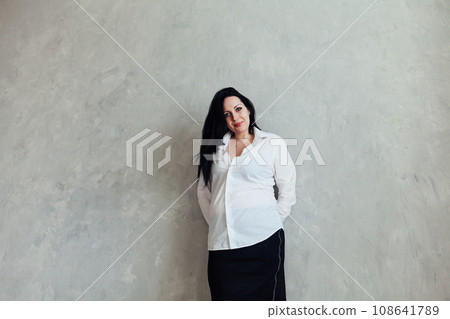 Portrait of a beautiful brunette woman in a white business suit Portrait of a beautiful brunette woman in a white business suit 108641789