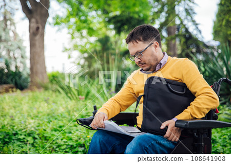 A person with disabilities with papers in the park A person with disabilities with papers in the park 108641908