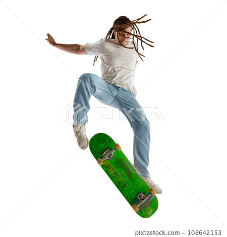 Dynamic portrait of young man with dreadlocks performing tricks on skateboard in air in motion. Concept of youth culture. 108642153