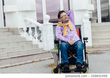 a special person with disabilities at the stairs of an office building 108642498