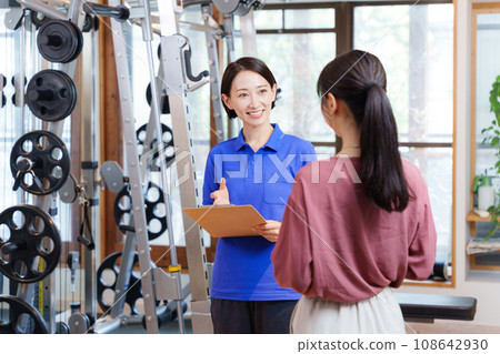 Staff and customers providing information on joining a sports gym 108642930