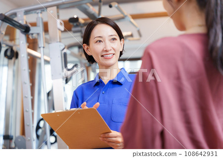 Staff and customers providing information on joining a sports gym 108642931