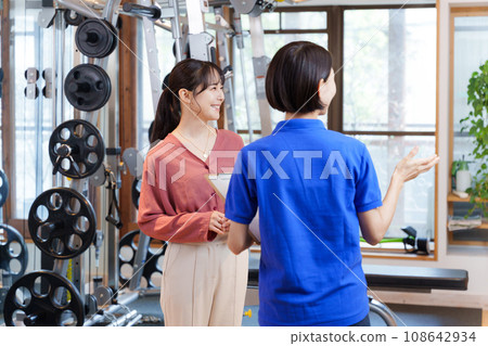 Staff and customers providing information on joining a sports gym 108642934