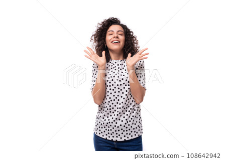 young well-groomed brunette curly woman dressed in a blouse with a pattern of peas young well-groomed brunette curly woman dressed in a blouse with a pattern of peas 108642942