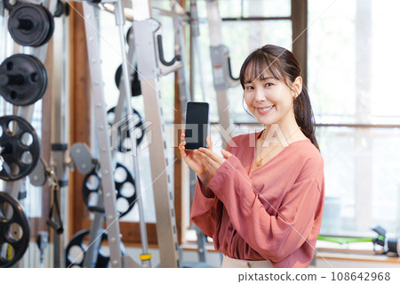 顧客在健身房展示智慧型手機螢幕 顧客在健身房展示智慧型手機螢幕 108642968