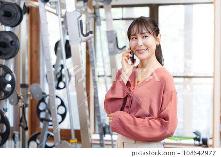 顧客在健身房用智慧型手機交談 顧客在健身房用智慧型手機交談 108642977