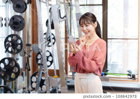 顧客在健身房使用智慧型手機 顧客在健身房使用智慧型手機 108642978