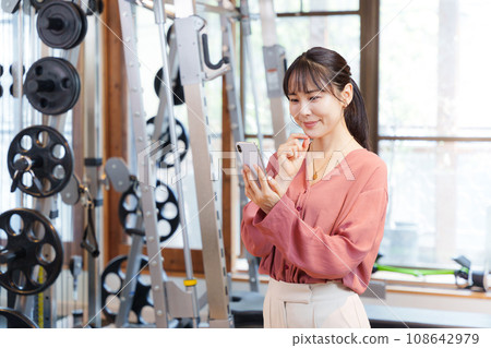 顧客在健身房使用智慧型手機 顧客在健身房使用智慧型手機 108642979
