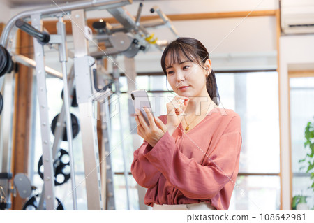 Customers using smartphones at the gym Customers using smartphones at the gym 108642981
