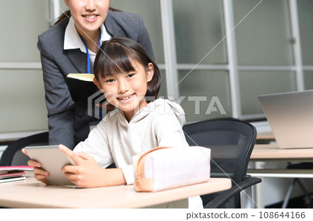 小學女生和老師用平板電腦設備教學 小學女生和老師用平板電腦設備教學 108644166