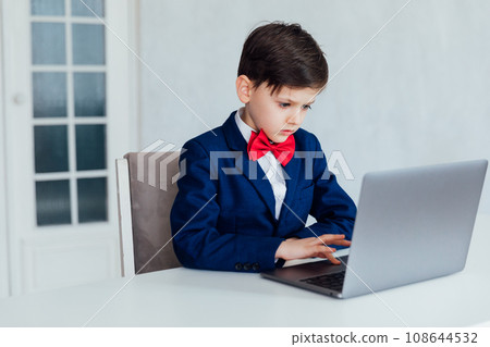 education IT knowledge child sitting at a laptop at school 108644532