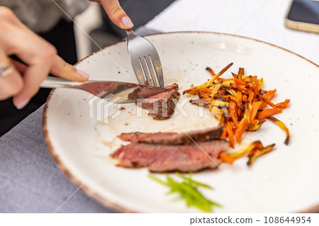 Woman eating delicious steak Woman eating delicious steak 108644954