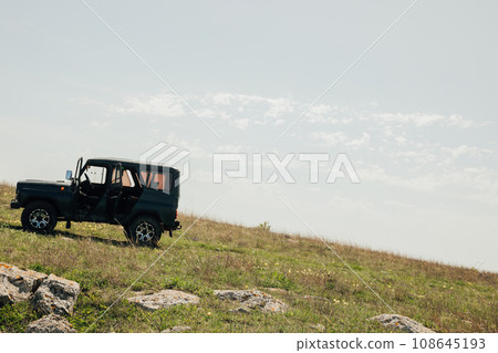 atomobil jeepy stands on a mountain in nature on a field 108645193
