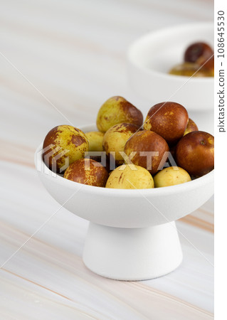 Green dates placed on a background board and served in a bowl. Green dates placed on a background board and served in a bowl. 108645530