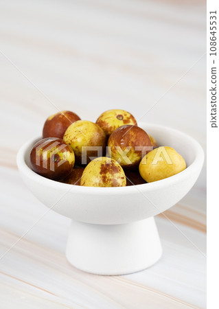 Green dates placed on a background board and served in a bowl. Green dates placed on a background board and served in a bowl. 108645531