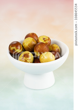 Green dates placed on a background board and served in a bowl. 108645534
