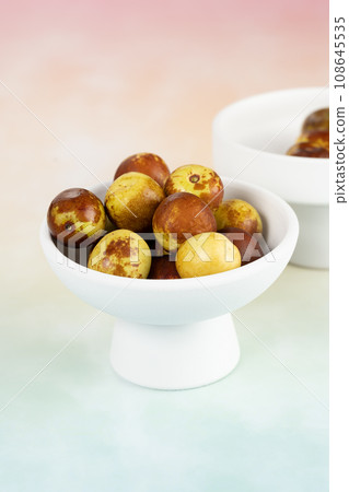 Green dates placed on a background board and served in a bowl. Green dates placed on a background board and served in a bowl. 108645535