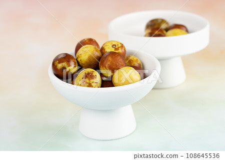 Green dates placed on a background board and served in a bowl. 108645536