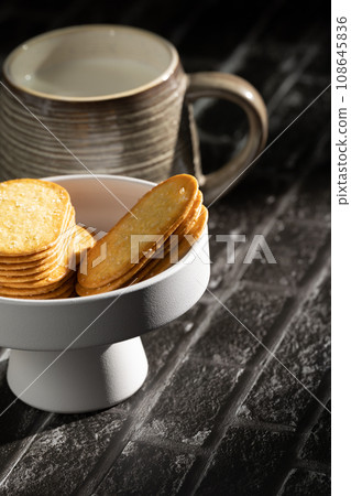 Sunlight shining on a slate board with a cup of milk and cookies. 108645836