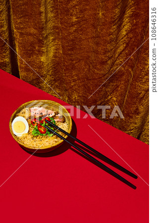 Asian culture, cuisine. Popular recipes. Plate with noodles, egg and meet, served with greenery isolated red background. 108646316