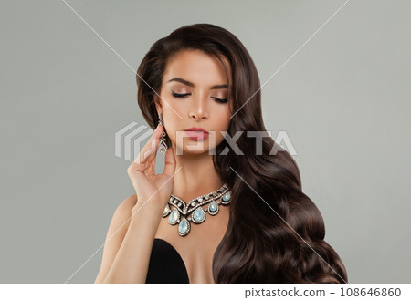Beautiful young fashion model woman brunette with long shiny curly hair, diamond jewelry earring Beautiful young fashion model woman brunette with long shiny curly hair, diamond jewelry earring 108646860
