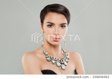 Attractive stylish woman with short hair wearing diamond jewelry earring and necklace posing Attractive stylish woman with short hair wearing diamond jewelry earring and necklace posing 108646862