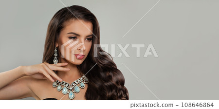 Glamorous brunette model woman with long wavy hairdo, diamond jewelry earring and necklace Glamorous brunette model woman with long wavy hairdo, diamond jewelry earring and necklace 108646864