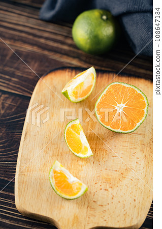 Oranges placed on a wooden board 108647184