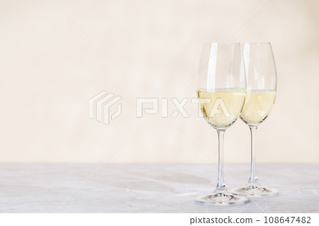 Two champagne glasses on a beige Two champagne glasses on a beige 108647482