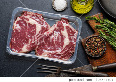 Raw ribeye steaks with savory spices 108647505