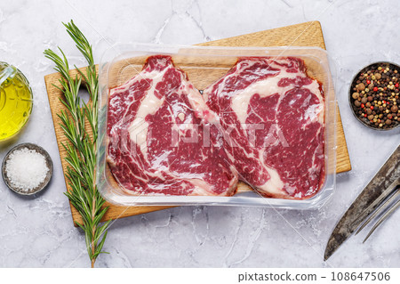 Raw ribeye steaks with savory spices Raw ribeye steaks with savory spices 108647506