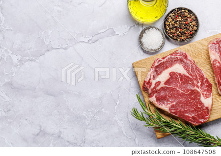 Raw ribeye steaks with savory spices 108647508