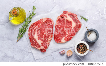 Raw ribeye steaks with savory spices 108647514