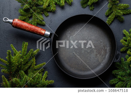 Empty frying pan, Christmas Fir tree branches Empty frying pan, Christmas Fir tree branches 108647518