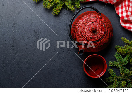 Teapot, cup, and fir tree branches create a cozy scene Teapot, cup, and fir tree branches create a cozy scene 108647551