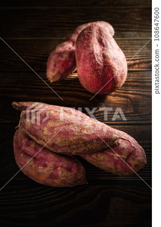 Old sweet potatoes placed on a wooden board. Old sweet potatoes placed on a wooden board. 108647600