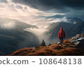 Silhouette of a tourist with a backpack in a red jacket, standing on top of a mountain and observing the beauty of the natural landscape. View of the mountains, forest and clouds 108648138