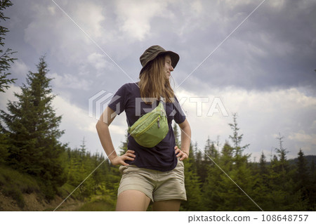 Girl is hiking in the mounntains and forest with waist bag. 108648757