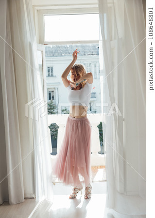 Beautiful blonde posing near the balcony in the room Beautiful blonde posing near the balcony in the room 108648801