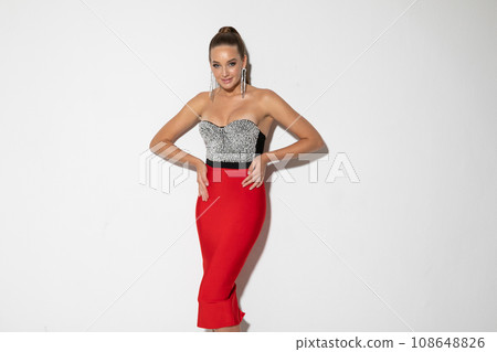 woman in festive dress posing in bright room on white background 108648826